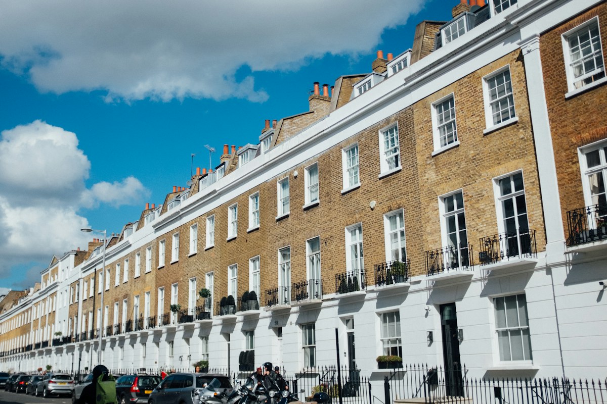 Row of traditional terraced houses under a blue sky — illustrative stock photograph